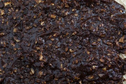 Coating chocolate topping with wallnuts on cake crust Stock Photos