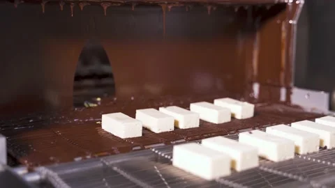 Coating delicate white souffle with hot melted chocolate at the factory. Stock Footage 225355275