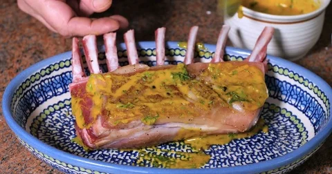 Coating a rack of lamb with mustard and breaded mint crust Stock Footage 73527649