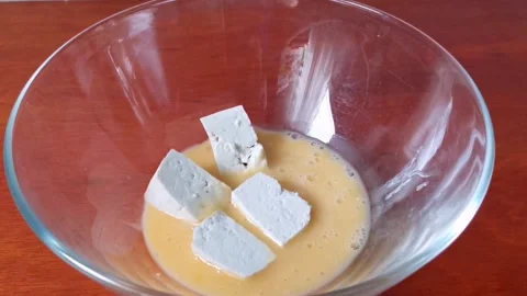 Coating Raw Tofu Cubes on Beaten Egg Stock Footage 234882146