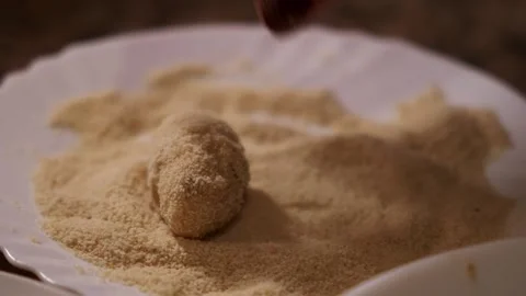Coating spanish croquetas with breadcrumbs, close up shot. 動画素材 345598705