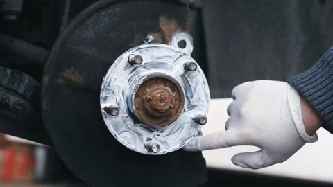 Coating wheel hub mating surface with graphite anti seize compound during brake Stock Footage 337417796