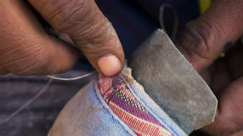 A cobbler sitting by the roadside pavement Stock Footage 75265646