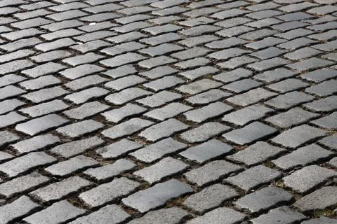 Cobblestone background abstract. Granite cobbles. Old street surface. Stock Photos