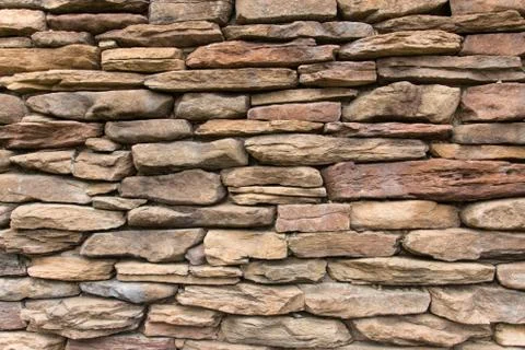 Cobblestone brick wall with brown bricks. Stock Photos