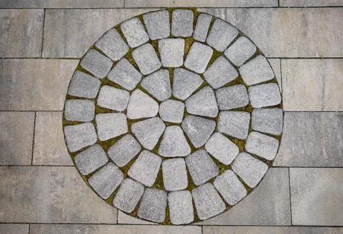 Cobblestone circle pattern forming a design on modern outdoor paving Stock Photos