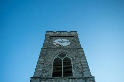 A Cobblestone Clocktower on a Clear Blue Sky Foto stock