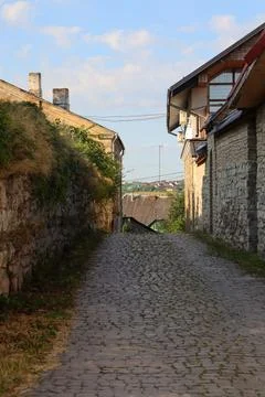 Cobblestone path between stone buildings in a small town during daytime Stock Photos