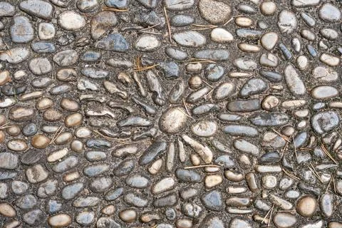 A cobblestone path shows a sun pattern made from arranged stones. 스톡 사진