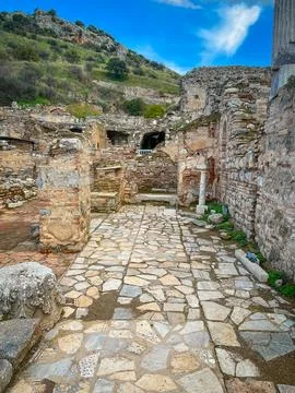 Cobblestone Path Winds Through Crumbling Ruins on Lush Hillside Stock-Fotos