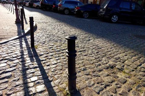 Cobblestone Pathway Lined With Guardrails Creates a Charming Urban Street V.. Stock Photos