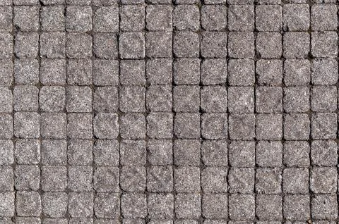 Cobblestone pavement arranged in grid pattern on outdoor surface Stock Photos