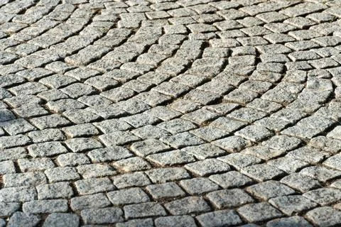 Cobblestone pavement with a curved pattern in a city street during daytime Foto stock