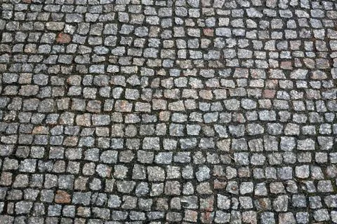 Cobblestone pavement surface with irregularly shaped stones in various shad.. Stock Photos