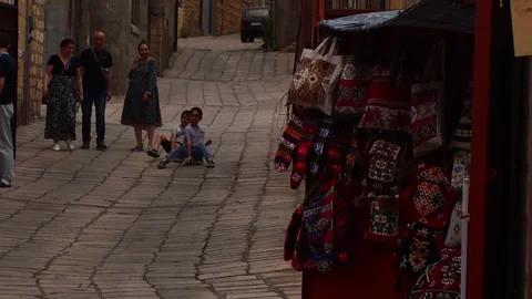 Cobblestone street with two adults and two children. The adults are a middle Stock Footage 318540468