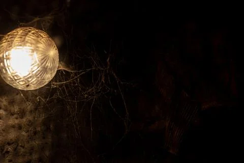 Cobweb in the light of a lantern in a dark, scary, damp room not far from the Stock Photos