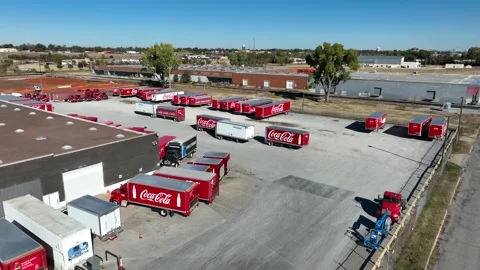 Coca Cola bottling plant distribution center. Red Coke trucks in parking Stock Footage 226882504