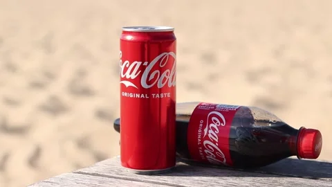 Coca-Cola can and bottle on wooden table on beach background Video stock 334246982