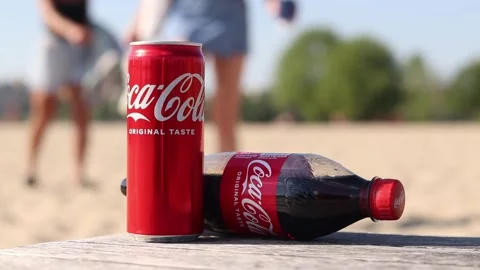 Coca-Cola can and bottle on wooden table on beach background Stock Footage 334246985