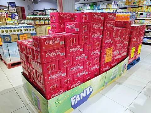 Coca Cola drink cans in packaging displayed for sale Stock Photos