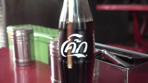 Coca-Cola drink in a Thai language bottle on the table. Video stock 294384470