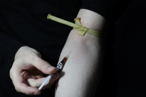 A cocaine addict while injecting himself with cocaine. Stock Photos