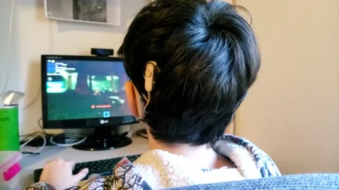 Cochlear implant Child playing roblox with computer 3 Stock Footage 138473055