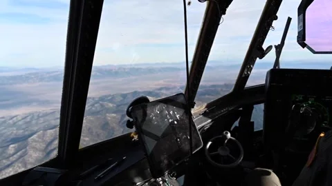 From the cockpit U.S. Air Force pilot flying C-130 Super Hercules over mountains Stock Footage 294335774