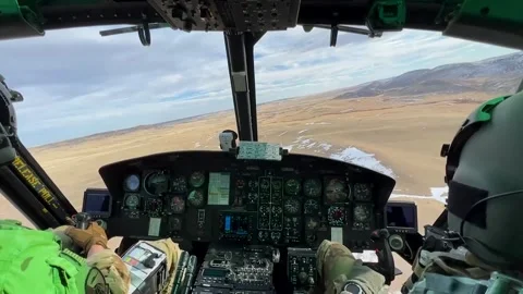 Cockpit view of U.S. Air Force UH-1N Huey flying over desert dusted with snow Stock Footage 260223393