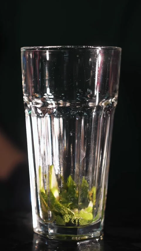 Cocktail. Bartender makes a cocktail. close-up. Bartender crushes mint leaves Stock Footage 315755686