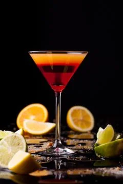 Cocktail drink on black background, citrus fruit on the table. Stock Photos