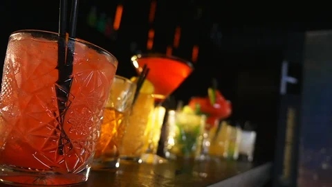 Cocktail Drinks Lined Up on a Bar Table During a Night Party Stock Footage 129538697