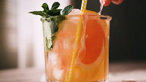 Cocktail with grapefruit, mint and ice, pan shot. Lemonade, close up. Stock Footage 123863016