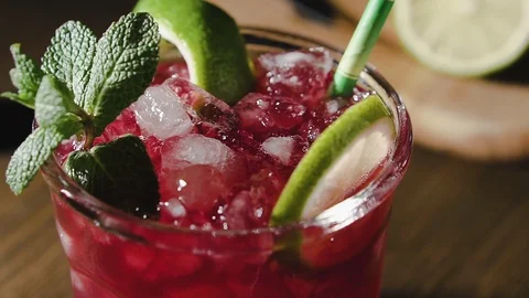 Cocktail with lime, mint and ice, pan shot, close up. Vídeo Stock 124038682