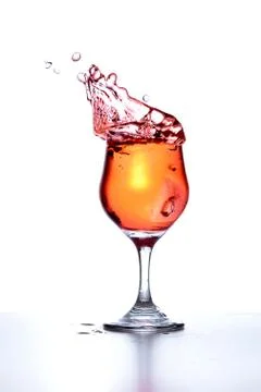 Cocktail splashes as ice is thrown in Stock Photos