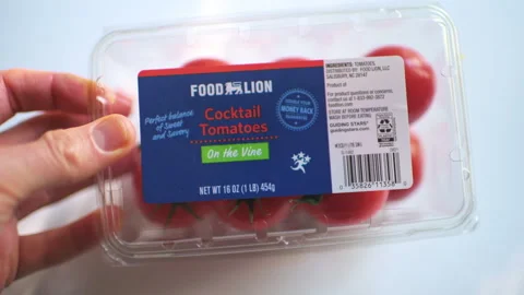 Cocktail tomato tomatoes in plastic container by Food Lion supermarket 스톡 동영상 330209757