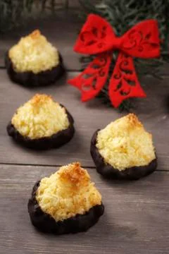 Coco macaroons with chocolate icing and Christmas decoration on wooden table, Foto stock