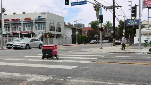 Coco Robotics autonomous food delivery robot crossing a pedestrian crosswalk Stock Footage 340569642