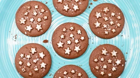 Cocoa and hazelnut biscuits on blue plate, top view close-up, rotating video Stock Footage 342188879