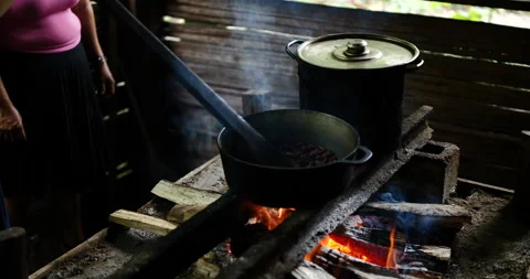 Cocoa beans cooked on an open fire. Person stirring a pot of cocoa beans. Stock Footage 154865888