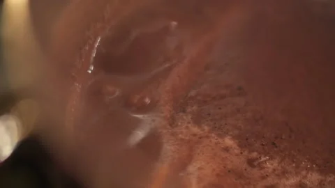 Cocoa is boiling in a pot, hot chocolate bubbling and foaming, close up Stock Footage 273482114