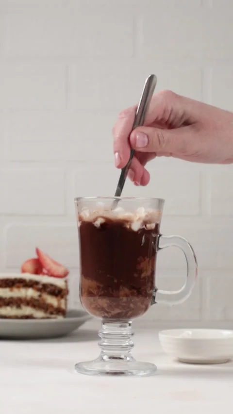Cocoa with marshmallows. The hand drops small marshmallows into hot chocolate Stock Footage 190069584