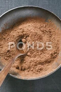 Cocoa Powder In Bowl With Wooden Spoon