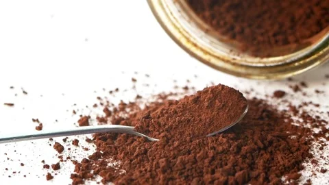 Cocoa powder falling over a spoon on a white background Stock Footage 160811784