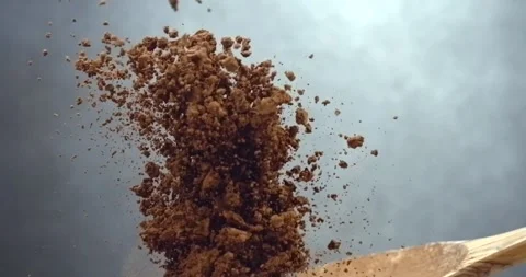 Cocoa powder falling from wooden spoon chocolate dust cloud slow motion Stock Footage 342590997