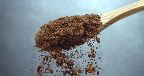 Cocoa powder falling from wooden spoon chocolate dust cloud slow motion Stock Footage 344850253