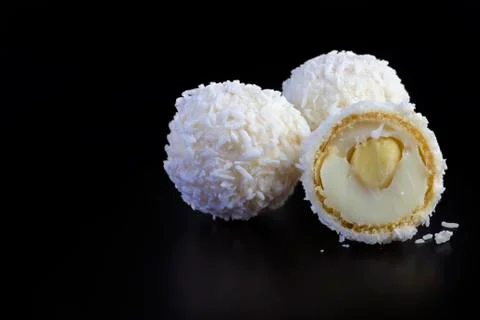 Coconut balls on black background Stock Photos