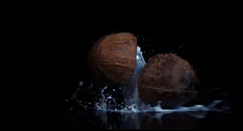 Coconut broken in slow motion on black background Stock Footage 66021633