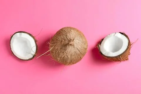 Coconut with brown shell and white flesh on pink background Fotos de archivo