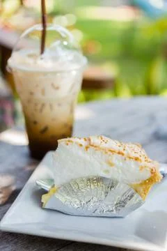 Coconut cake on table with ice coffee Stock Photos